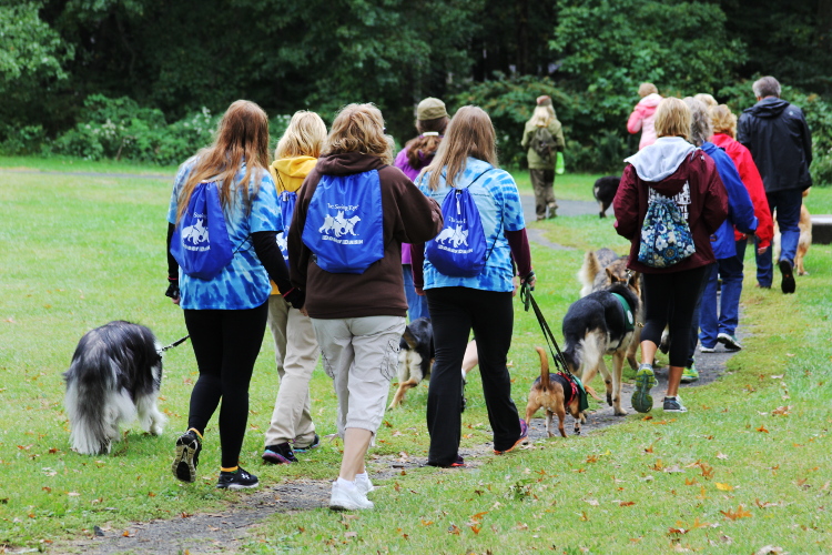 Walkers wearing Doggy Dash back packs from the event goody b